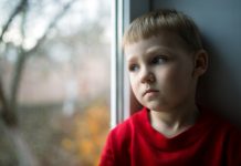 ‘Zorg dat kinderbijslag echt aan het kind wordt uitgegeven’ Kind kijkt uit raam