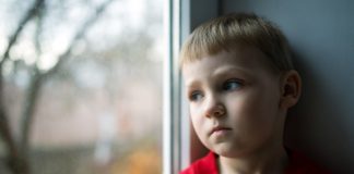 Kind kijkt uit raam