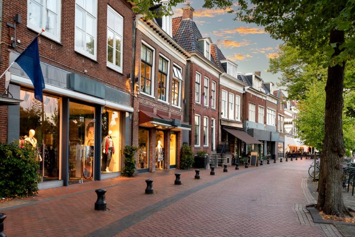 Small shopping street with restaurants in Diepswal street at evening, Dokkum, Netherlands Lokale ondernemers spelen grote rol in zorgzame buurten